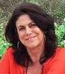 Smiling female author in red blouse with long black hair leaning her head to the side